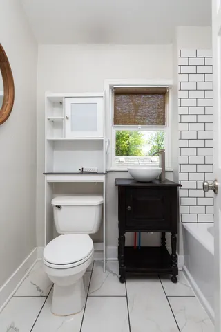 a bathroom with a toilet a sink and a window