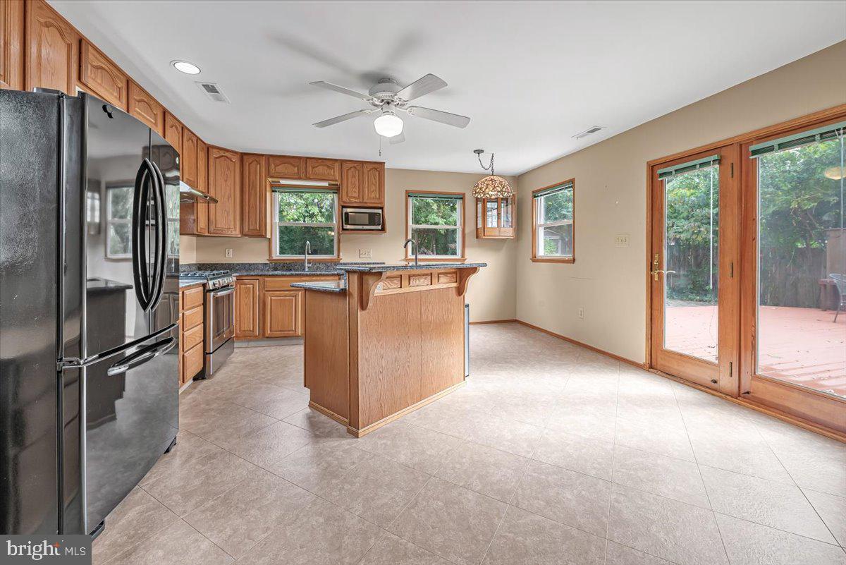 10101 Portland Road Silver Spring, MD 20901 - Photo 2 of 33 a open kitchen with stainless steel appliances granite countertop a refrigerator a sink a stove and oven with wooden floor