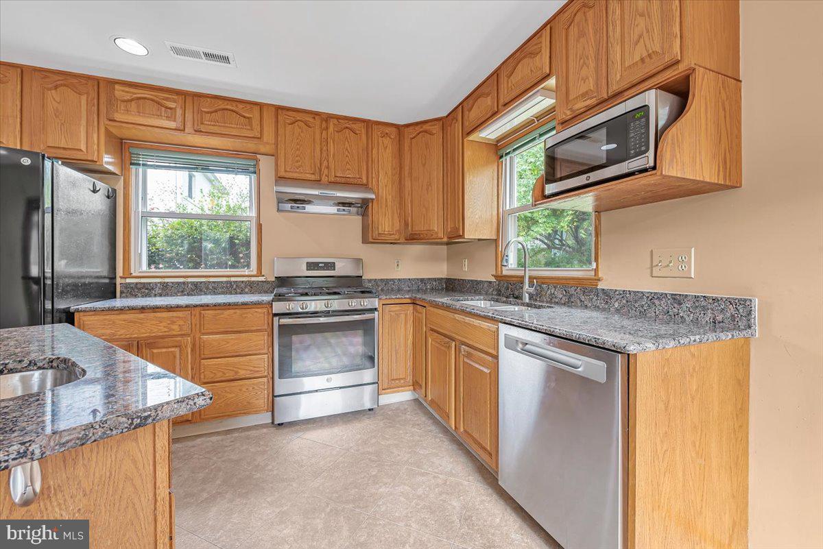 10101 Portland Road Silver Spring, MD 20901 - Photo 4 of 33 a kitchen with stainless steel appliances granite countertop a stove a sink and a microwave