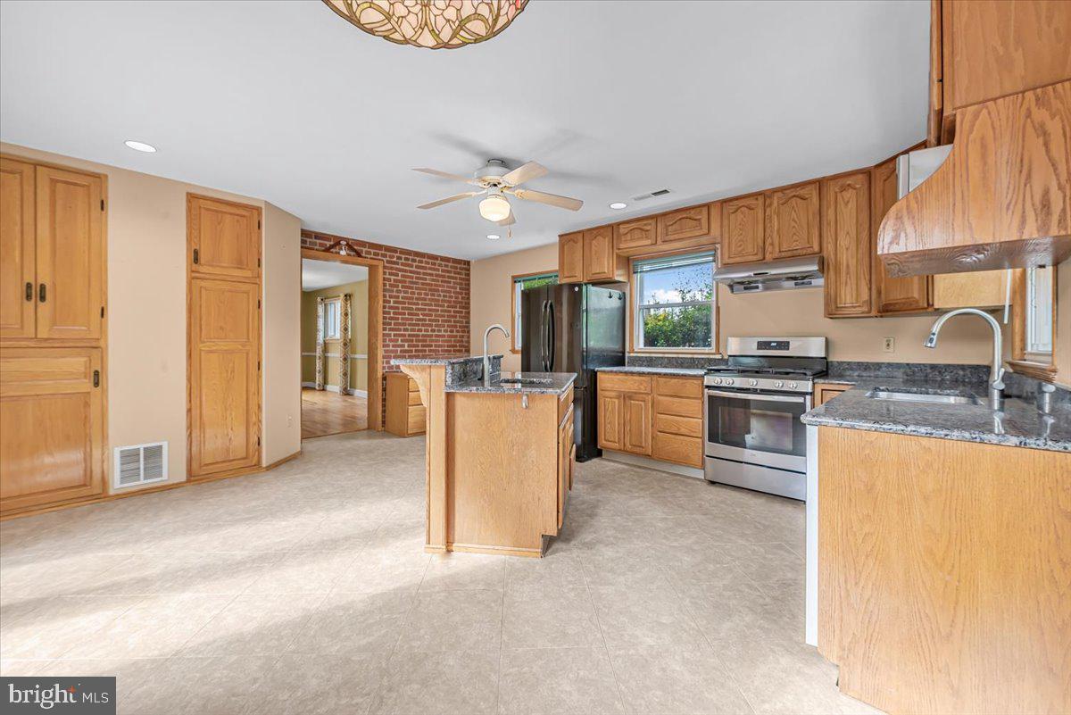 10101 Portland Road Silver Spring, MD 20901 - Photo 5 of 33 a kitchen with stainless steel appliances granite countertop a stove refrigerator sink and cabinets