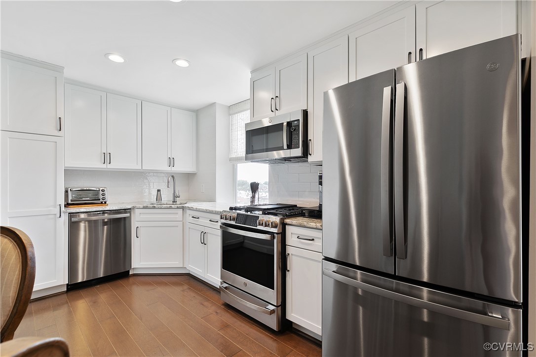 413 Stuart Circle, Unit 5E Richmond, VA 23220 - Photo 14 of 44 a kitchen with stainless steel appliances a refrigerator stove and sink