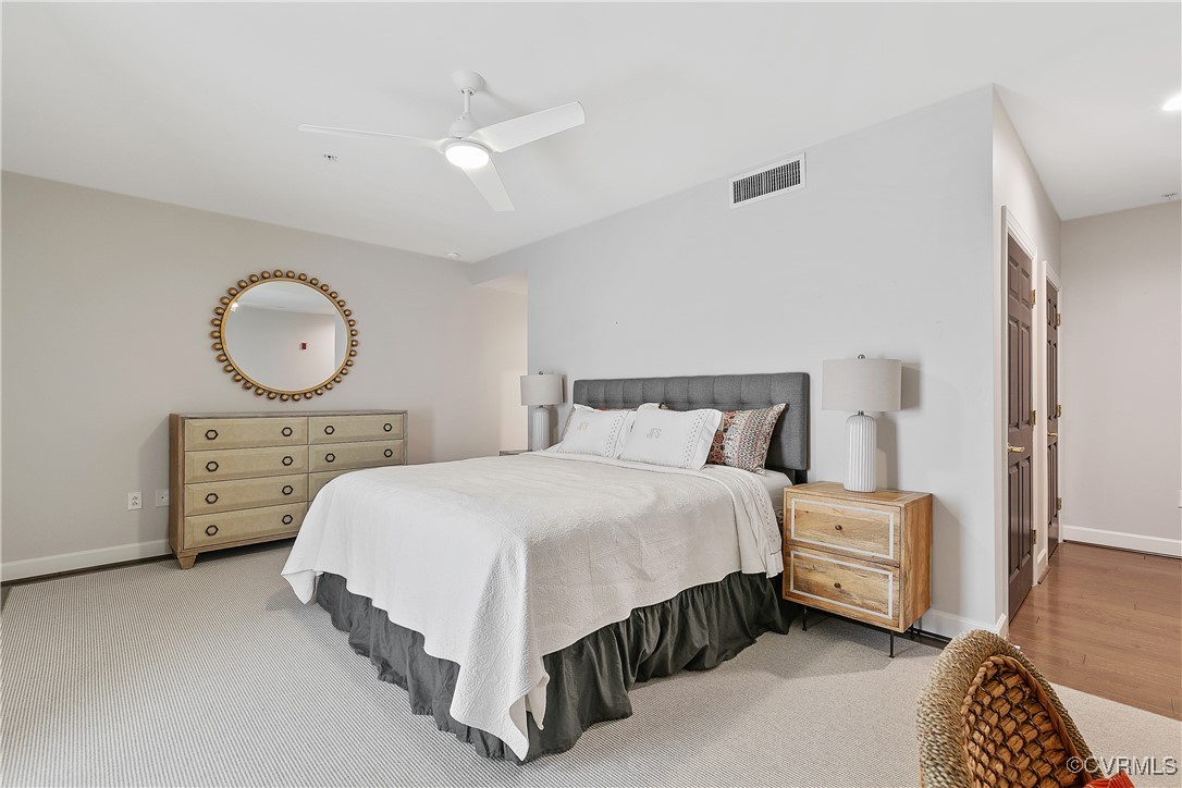 413 Stuart Circle, Unit 5E Richmond, VA 23220 - Photo 23 of 44 a bedroom with a bed a dresser and a mirror