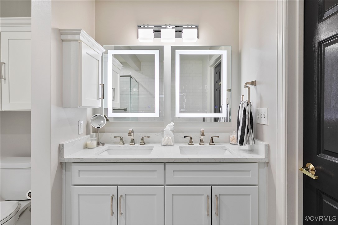 413 Stuart Circle, Unit 5E Richmond, VA 23220 - Photo 25 of 44 a bathroom with a double vanity sink and a mirror