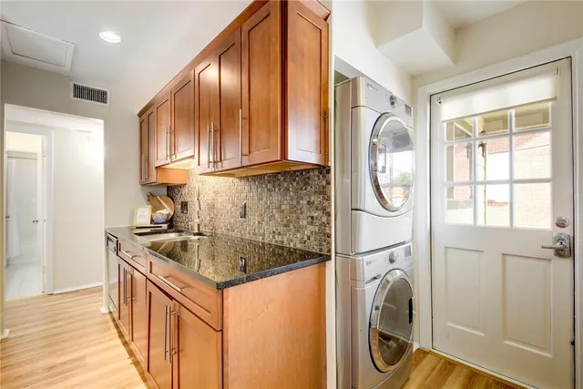 a kitchen with a sink a washer and dryer next to a window
