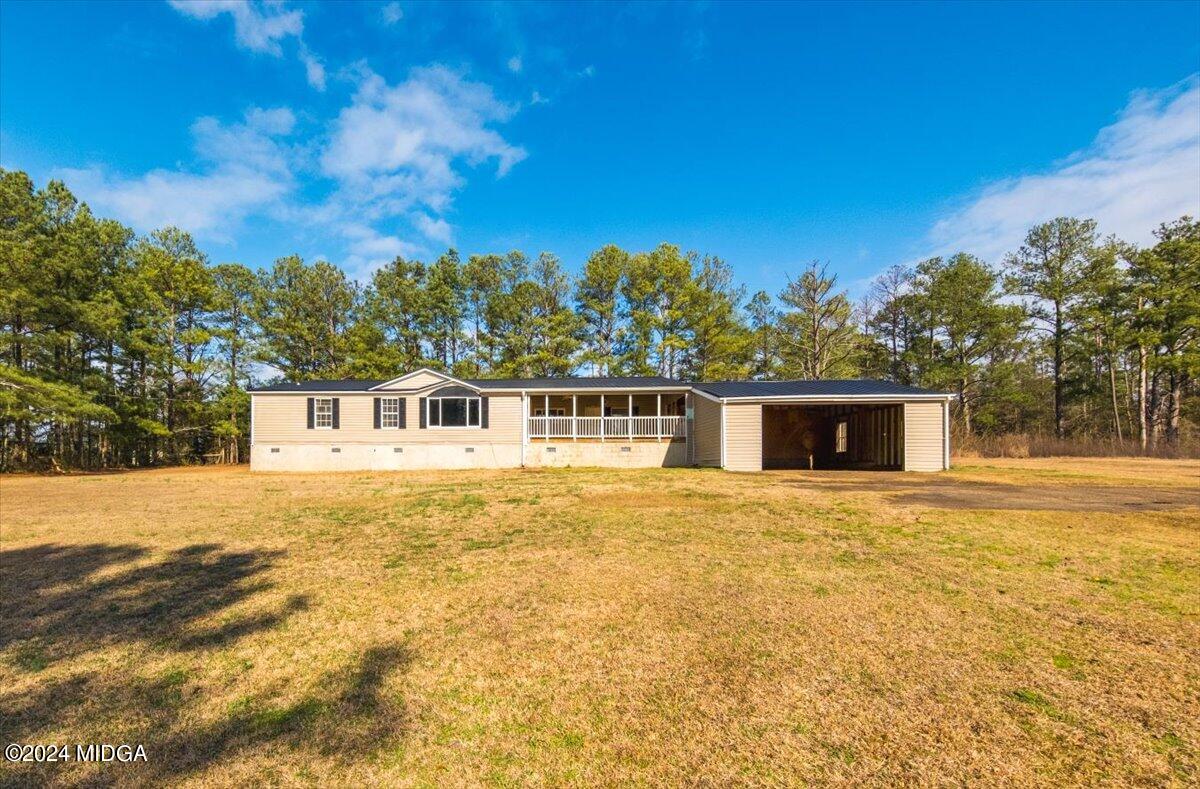 a front view of house with yard and trees in the background