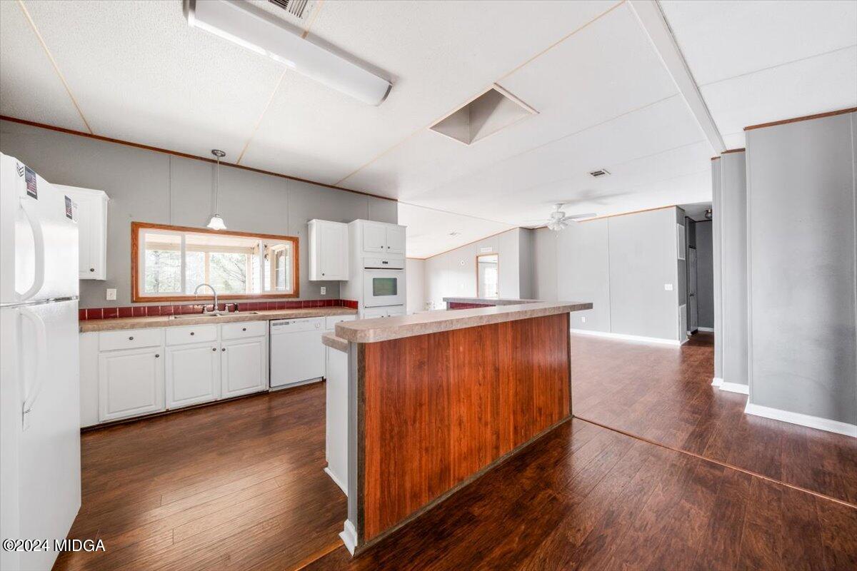 647 Gose Road Forsyth, GA 31029 - Photo 5 of 34 a kitchen with stainless steel appliances granite countertop a refrigerator a sink dishwasher a stove and white countertops with wooden floor