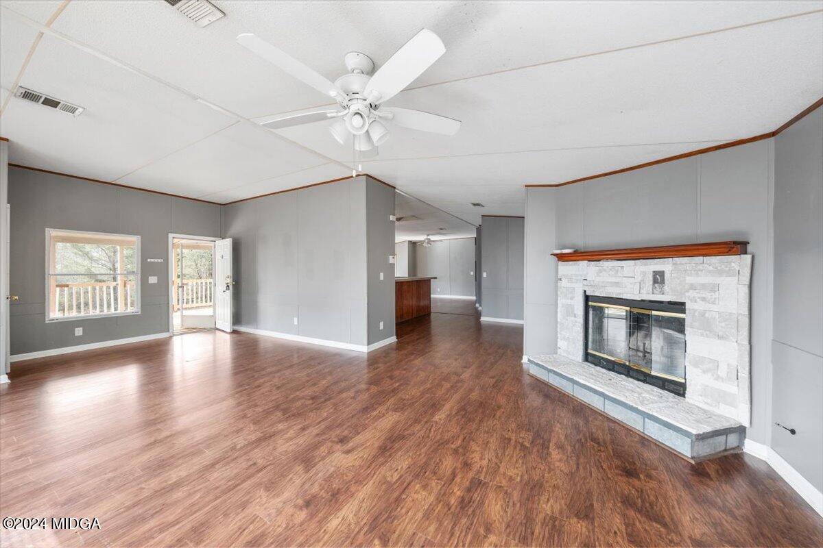 647 Gose Road Forsyth, GA 31029 - Photo 9 of 34 an empty room with wooden floor fireplace and windows