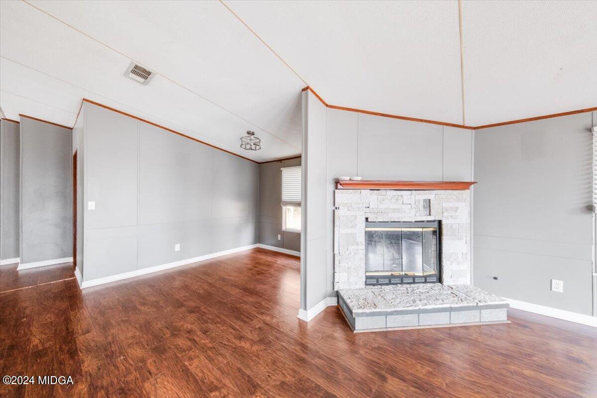 647 Gose Road Forsyth, GA 31029 - Photo 10 of 34 a view of a livingroom with wooden floor a fireplace and window
