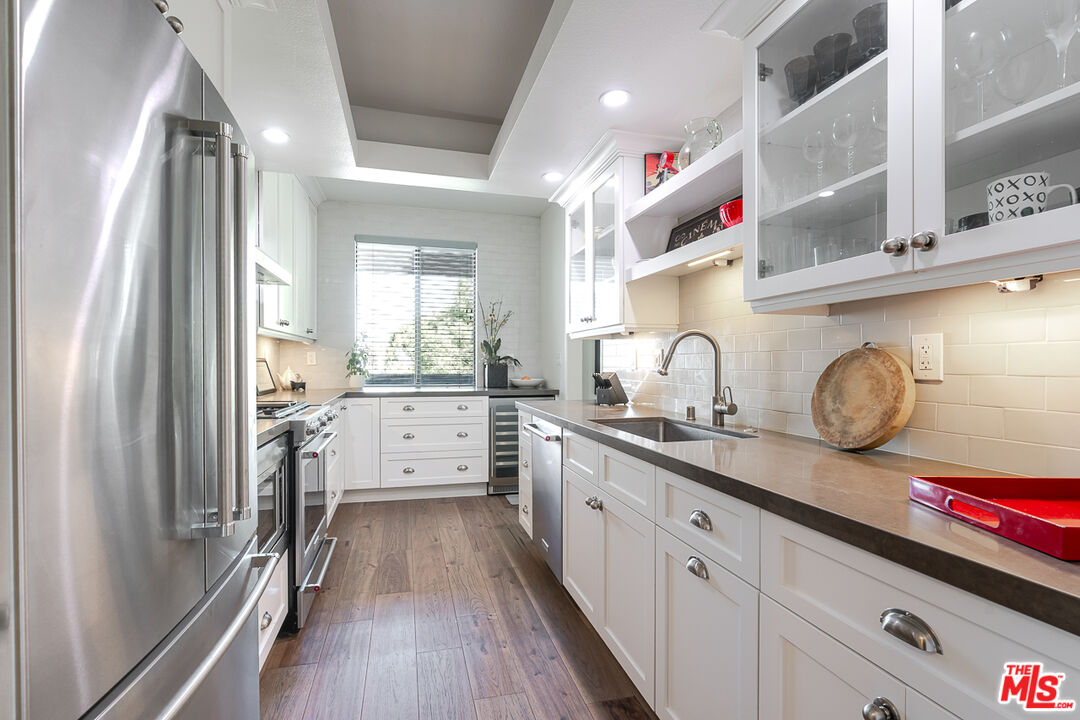 11322 Camarillo Street, Unit 201 Toluca Lake, CA 91602 - Photo 1 of 20 a kitchen with cabinets a sink and appliances