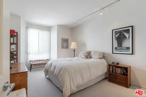 a bedroom with a bed couch and a window