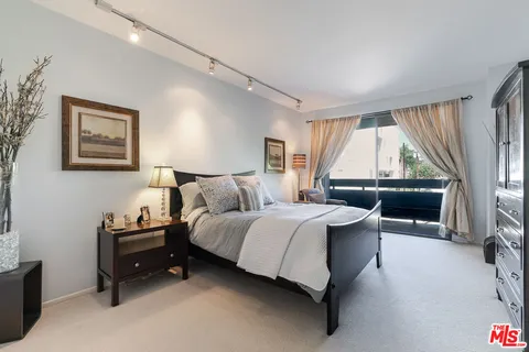 a bedroom with a bed couch and painting on the wall