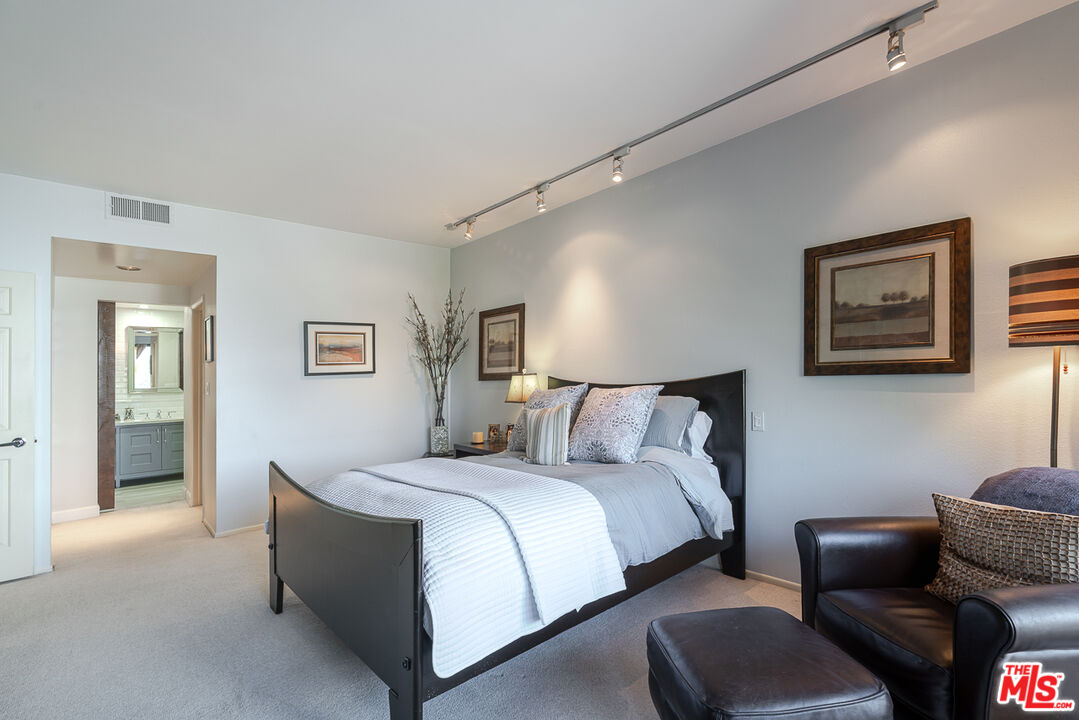 11322 Camarillo Street, Unit 201 Toluca Lake, CA 91602 - Photo 16 of 20 a bedroom with a bed couch and painting on the wall