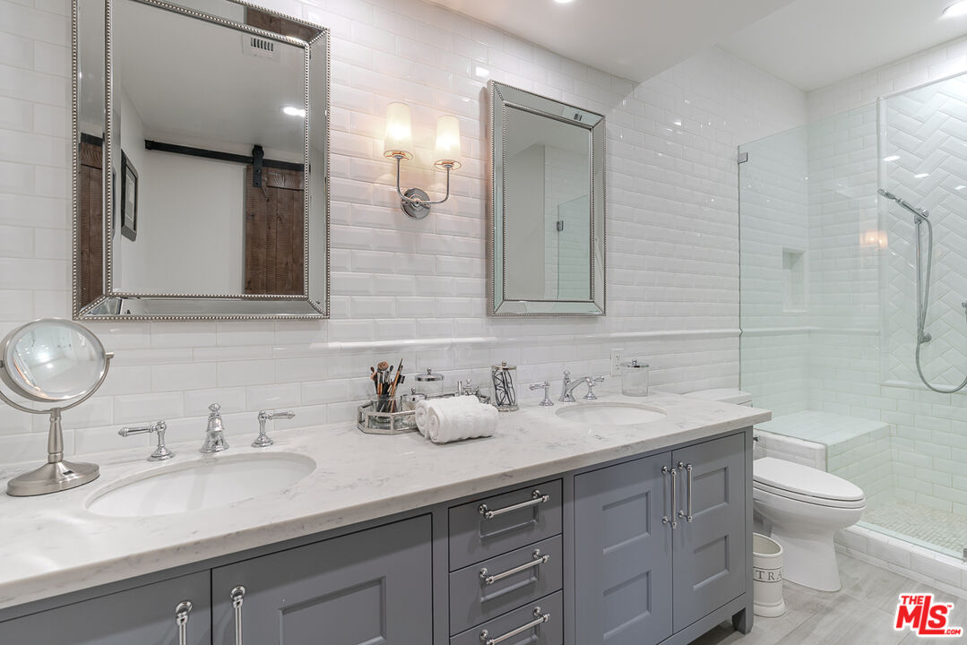 11322 Camarillo Street, Unit 201 Toluca Lake, CA 91602 - Photo 17 of 20 a bathroom with a sink double vanity and a mirror