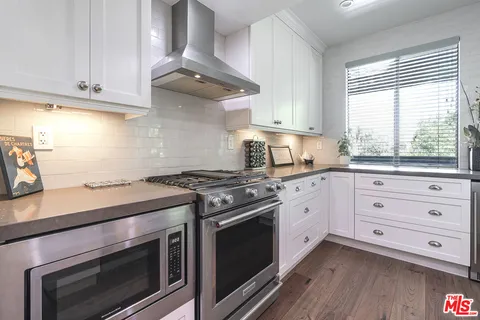 a kitchen with cabinets appliances and a window