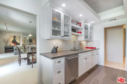 a kitchen with a sink dishwasher and a stove with wooden floors