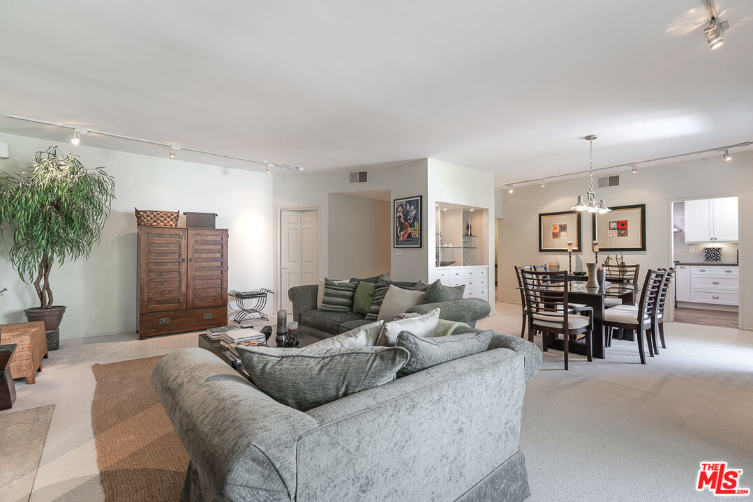 11322 Camarillo Street, Unit 201 Toluca Lake, CA 91602 - Photo 9 of 20 a living room with furniture and a dining table with wooden floor