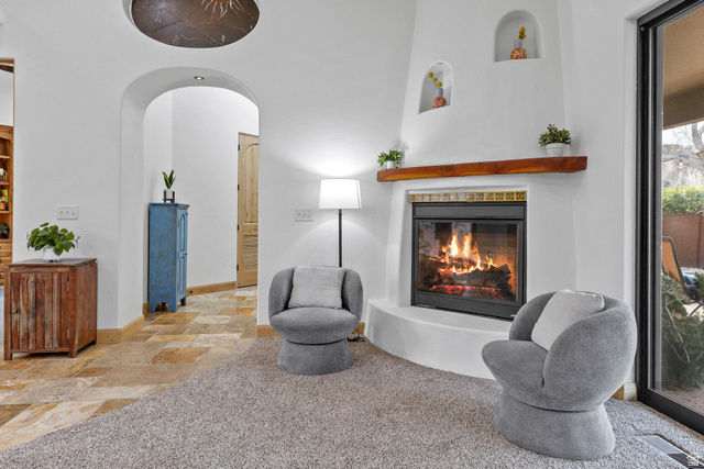 98 Bridge Road Rockville, UT 84763 - Photo 10 of 75 Sitting room with stone tile floors, arched walkways, a glass covered fireplace, and carpet