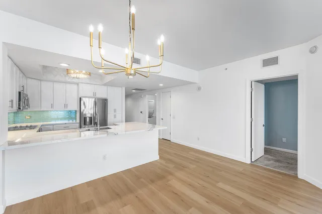 a view of a kitchen with kitchen island a sink and wooden floor