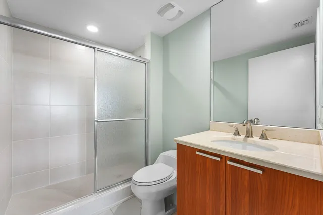 a bathroom with a granite countertop sink toilet and shower