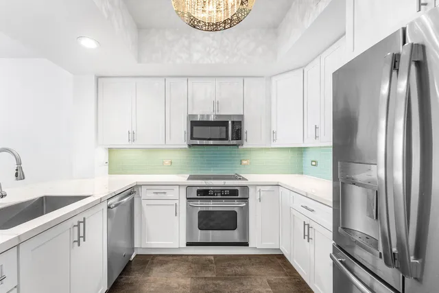 a kitchen with stainless steel appliances granite countertop a refrigerator and a stove top oven