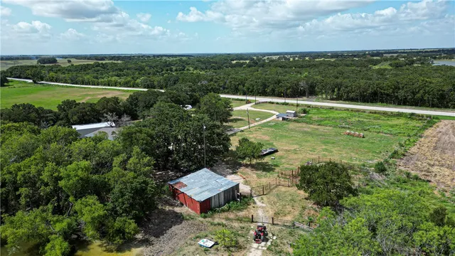 an aerial view of ocean and residential houses with outdoor space