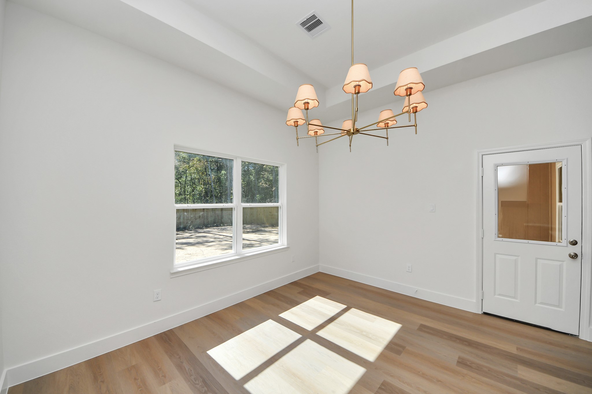 16276 Jeet Street Conroe, TX 77306 - Photo 13 of 36 a view of a room with wooden floor and chandelier