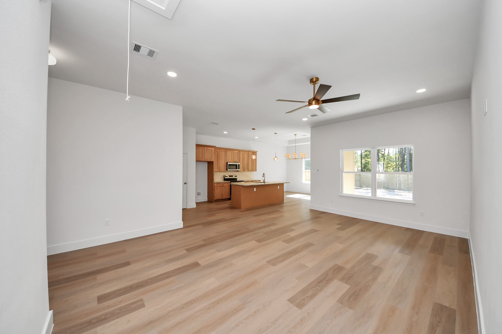 16276 Jeet Street Conroe, TX 77306 - Photo 5 of 36 a view of an empty room with a window and wooden floor