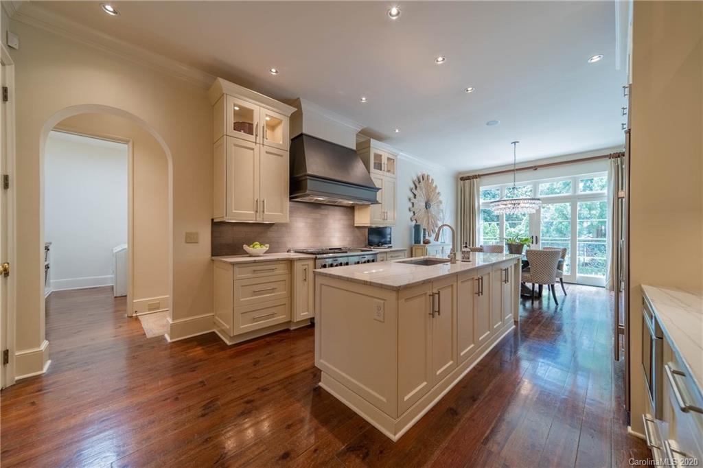 901 Colville Road Charlotte, NC 28207 - Photo 14 of 48 a kitchen with stainless steel appliances granite countertop white cabinets a sink dishwasher a stove and a refrigerator with wooden floor