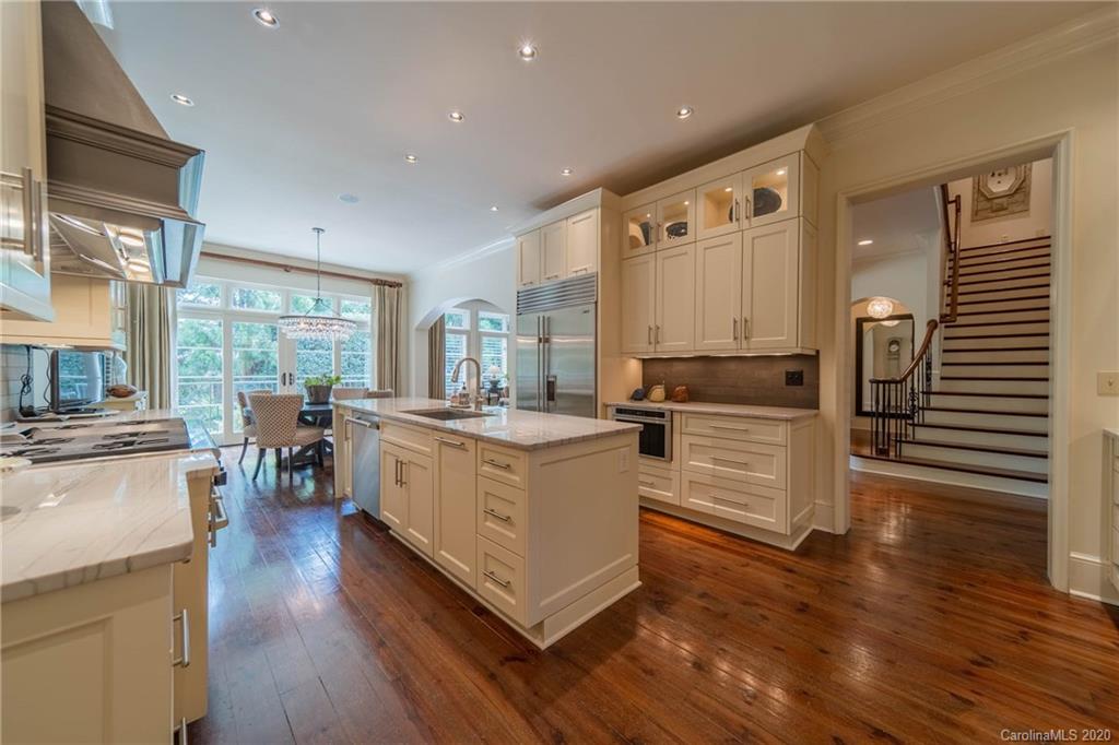 901 Colville Road Charlotte, NC 28207 - Photo 15 of 48 a kitchen with wooden floors and white cabinets