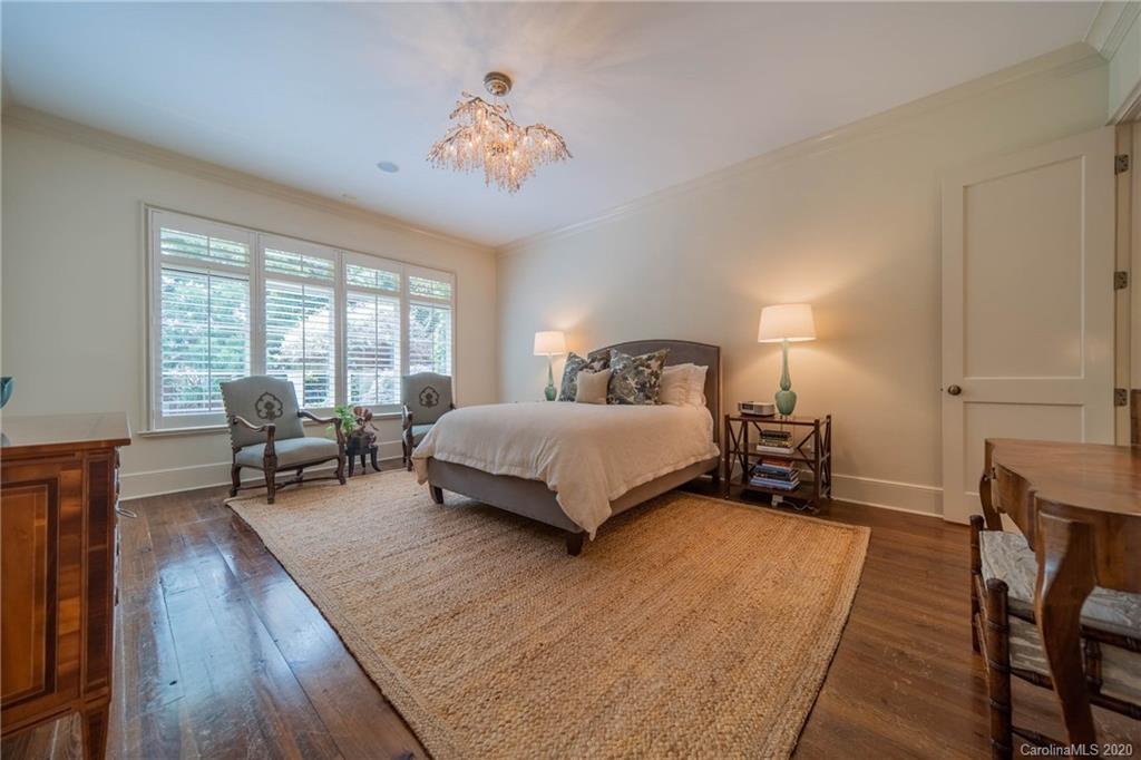 901 Colville Road Charlotte, NC 28207 - Photo 19 of 48 a bedroom with a bed and a chandelier