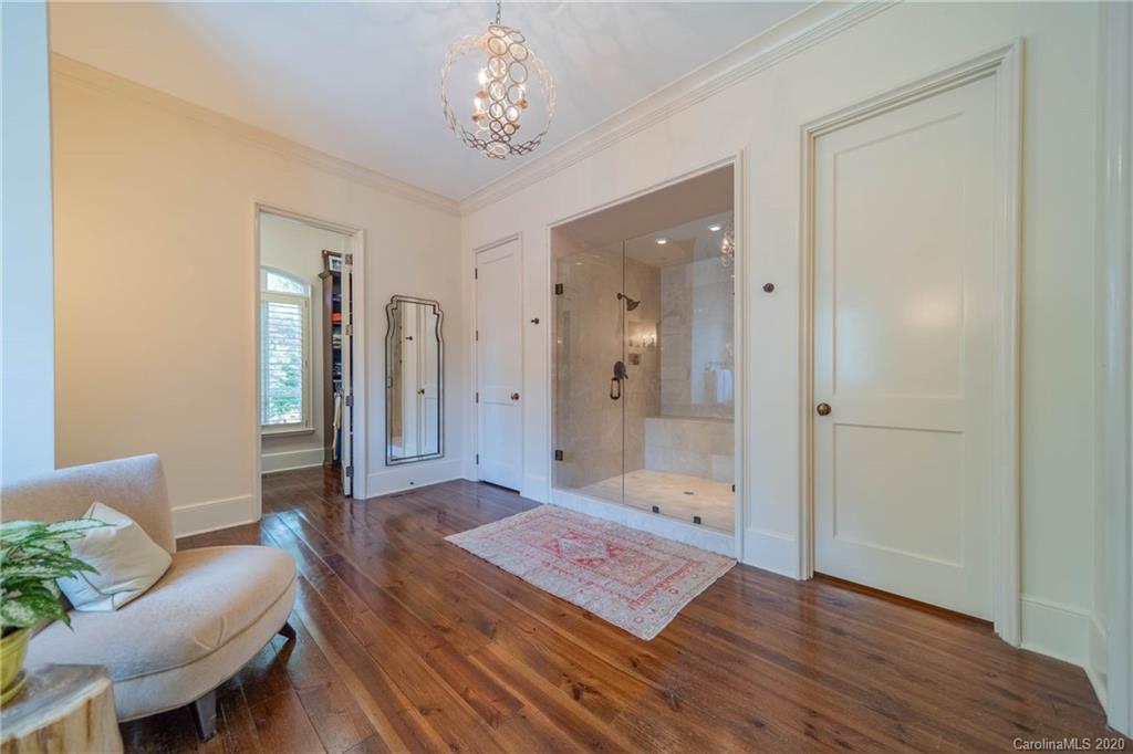 901 Colville Road Charlotte, NC 28207 - Photo 21 of 48 a spacious bedroom with a bed and a chandelier