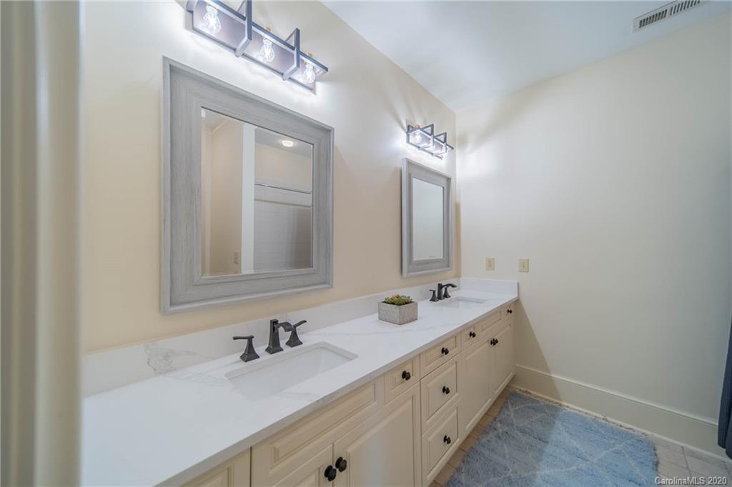 901 Colville Road Charlotte, NC 28207 - Photo 30 of 48 a bathroom with a double vanity sink and a mirror