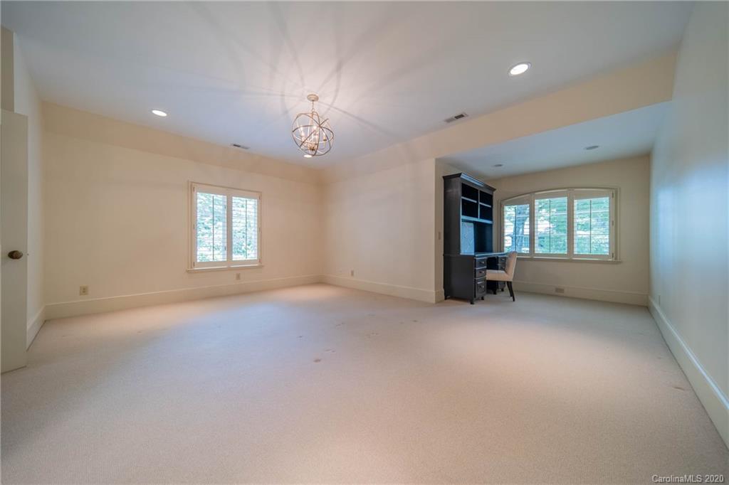 901 Colville Road Charlotte, NC 28207 - Photo 31 of 48 an empty room with windows and chandelier