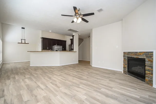 a view of an empty room with a window and wooden floor