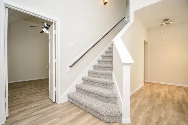 a view of a livingroom with a ceiling fan and wooden floor