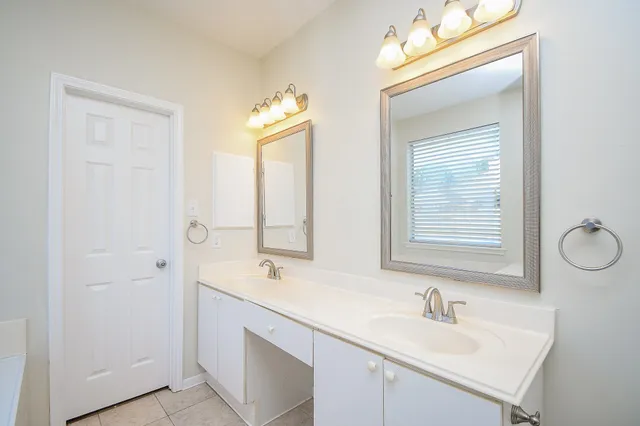 a bathroom with a tub sink and mirror