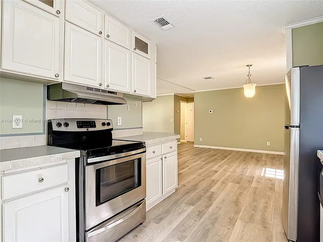 a kitchen with stainless steel appliances granite countertop a stove a refrigerator and a microwave