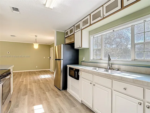a kitchen with a sink a refrigerator and window
