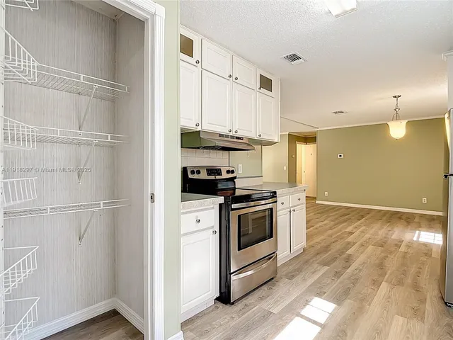 a kitchen with stainless steel appliances granite countertop a refrigerator a stove and a sink