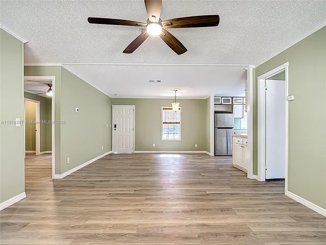 a view of empty room with wooden floor and window