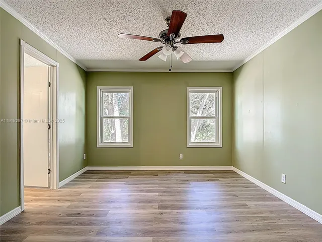 a view of a big room with wooden floor and windows