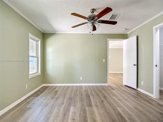 a view of a room with wooden floor and ceiling fan