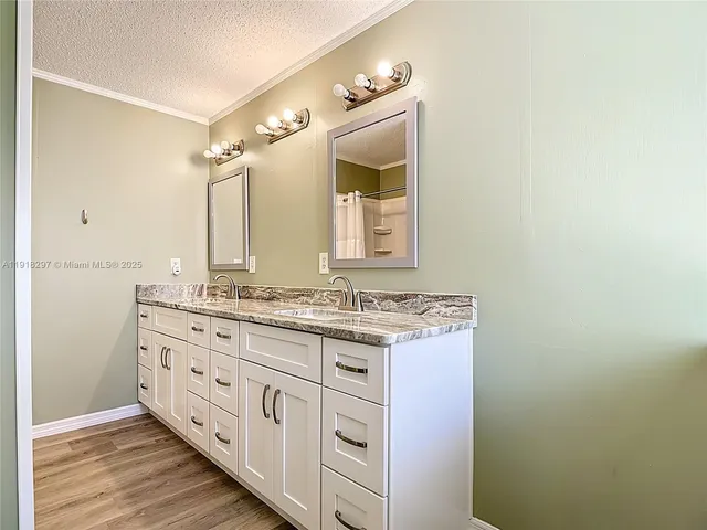a bathroom with a granite countertop sink mirror vanity and a toilet