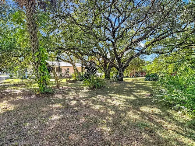 a view of yard with swimming pool and trees