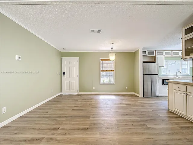 a view of empty room with wooden floor and window