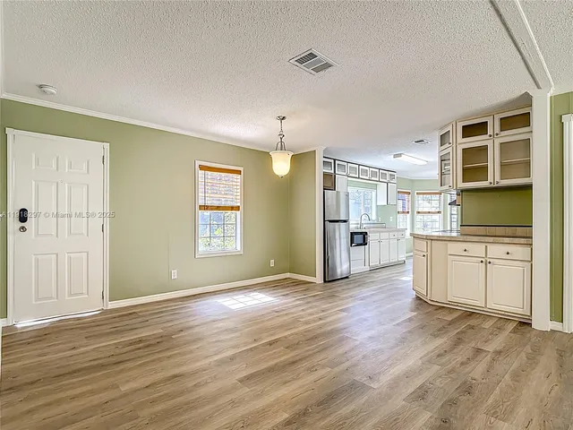 a view of an empty room with a kitchen