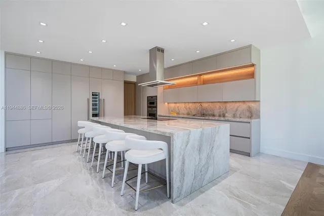 a large kitchen with a large counter top and stainless steel appliances
