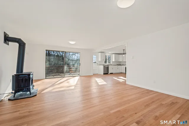 a view of empty room with wooden floor and fireplace