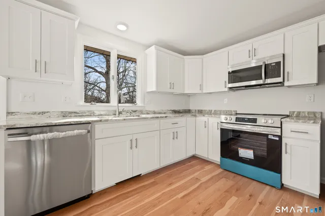 a kitchen with stainless steel appliances granite countertop a stove a microwave and a sink