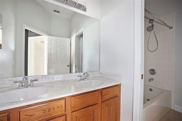 a bathroom with a double vanity sink mirror and shower